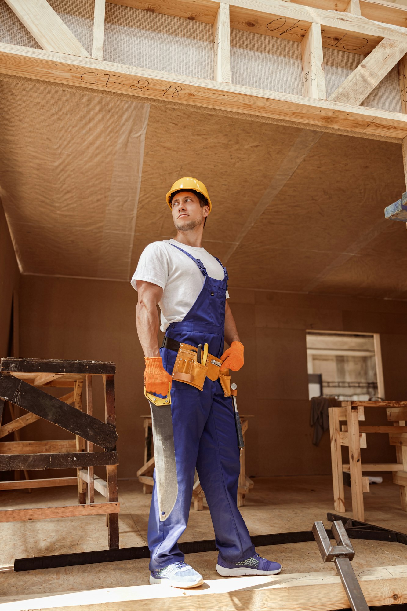 Male worker standing at house building construction site